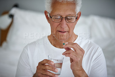 Buy stock photo Cropped shot of a senior man taking his medicine