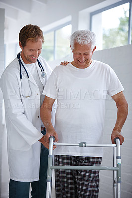 Buy stock photo Shot of a male doctor assisting his senior patient who's using a walker for support