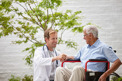Buy stock photo Shot of a male doctor talking to his senior patient who's in a wheelchair outside