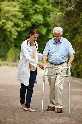 Buy stock photo Shot of a female doctor supporting her senior patient who's using a walker outside