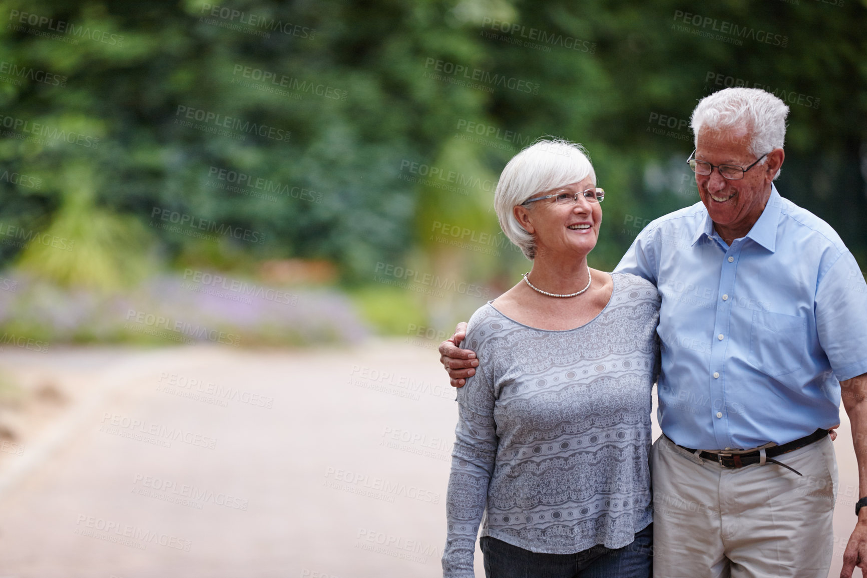 Buy stock photo Happy, senior couple and walking with hug in neighborhood for support, bonding or retirement together. Elderly, man and woman strolling with smile, embrace or love for commitment or morning in nature