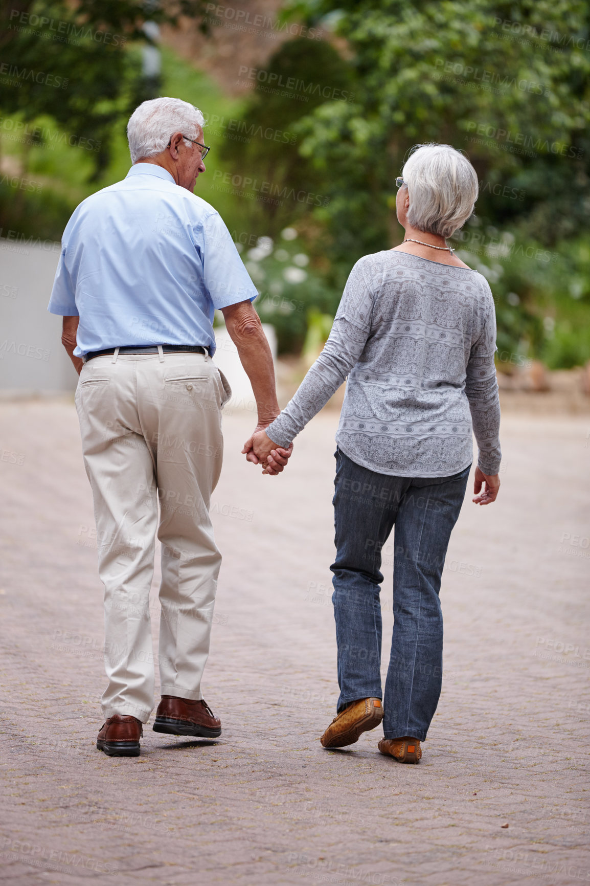 Buy stock photo Senior couple, holding hands and walking with support in neighborhood for relationship, bonding or care. Back view, elderly man and woman with love for togetherness, dating or romance in retirement