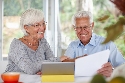 Buy stock photo Shot of a senior couple using a digital tablet and holding paperwork                                                                                                                 