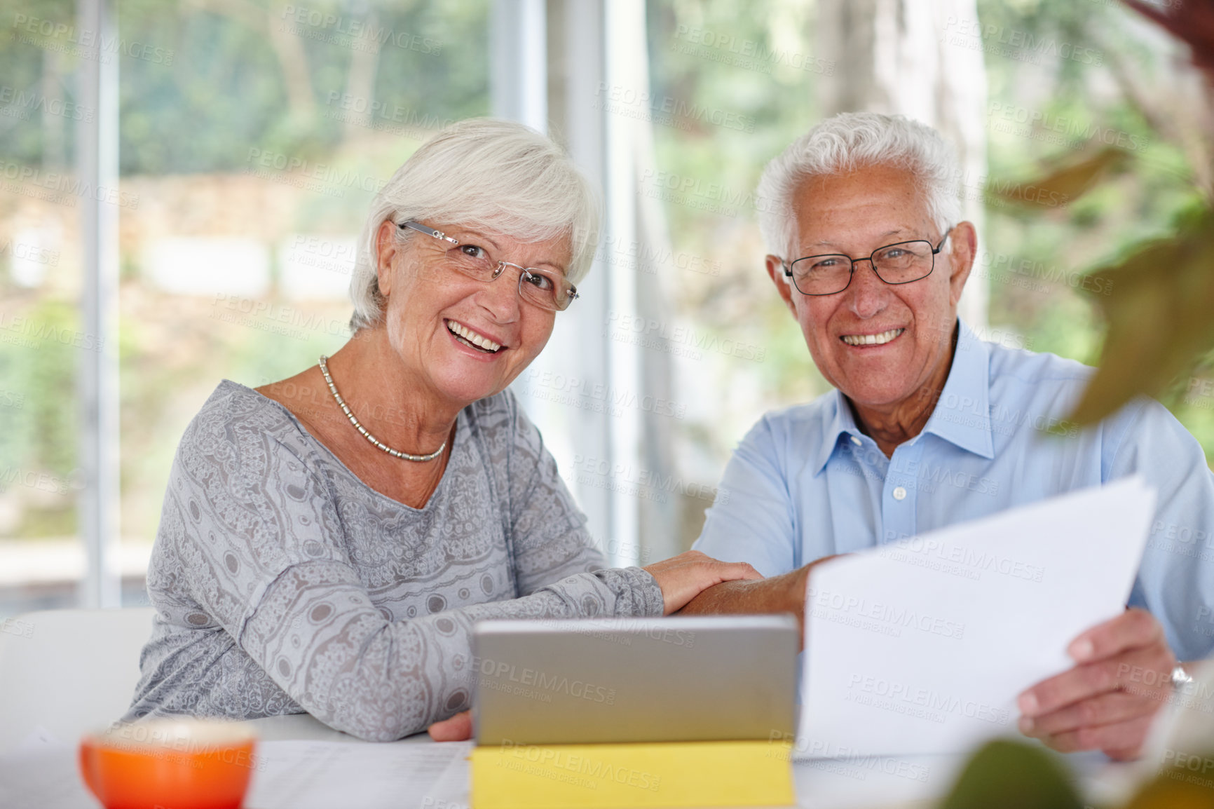 Buy stock photo Senior couple, tablet and paperwork for portrait with smile for profit, goal or investment growth in home. Elderly man, woman and documents with touchscreen, review or finance for retirement in Spain