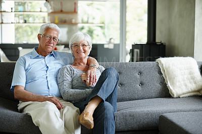 Buy stock photo Portrait of a happy senior couple sitting in their living room