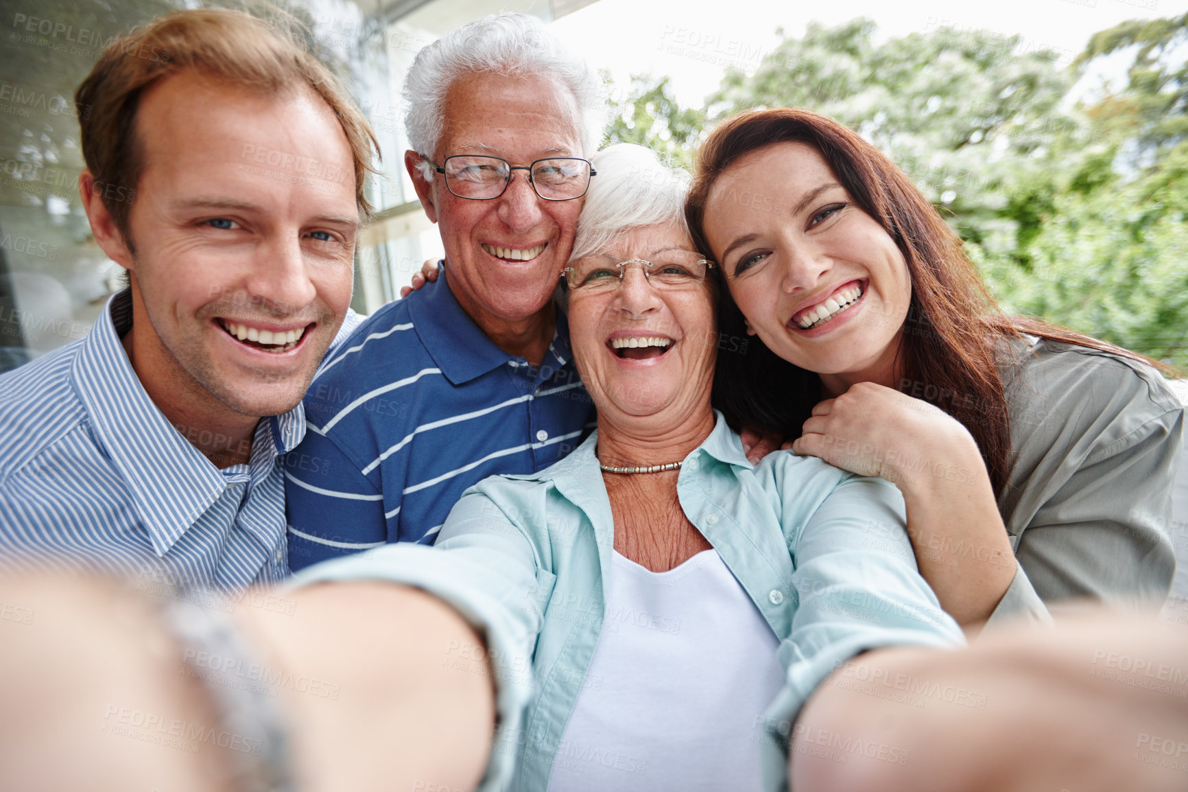 Buy stock photo Cropped shot of four adults taking a family selfie