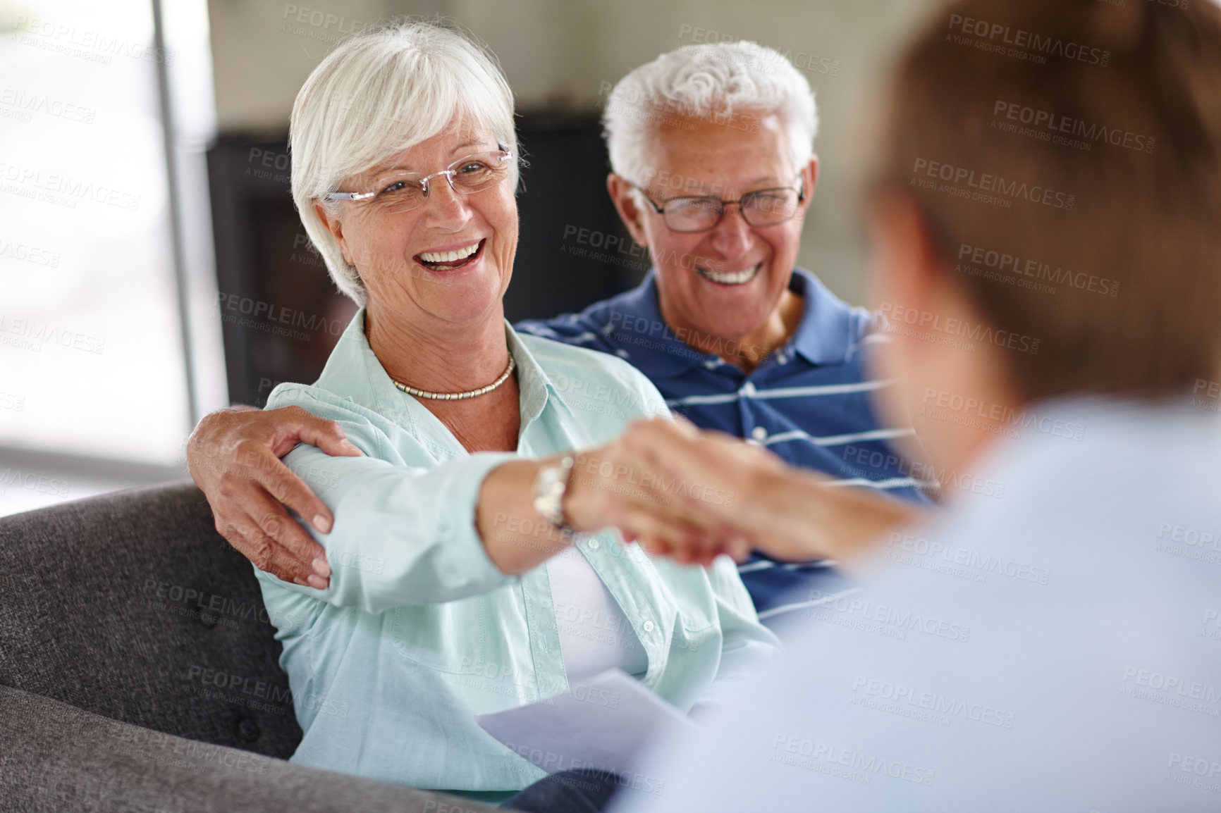 Buy stock photo Over-the-shoulder shot of a financial advisor meeting with a senior couple at their home