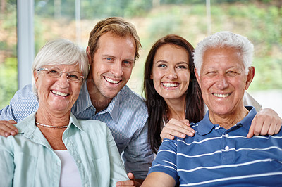 Buy stock photo Portrait of a happy family of four smiling at the camera