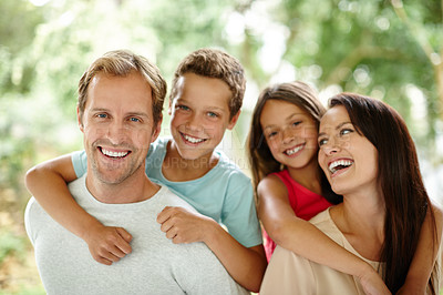 Buy stock photo Portrait of a happy family of four spending time together outdoors
