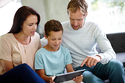 Buy stock photo Family, son and tablet for watching in home, elearning and helping child with virtual school. Parents, love and care for boy in living room with online games, streaming videos and learning together