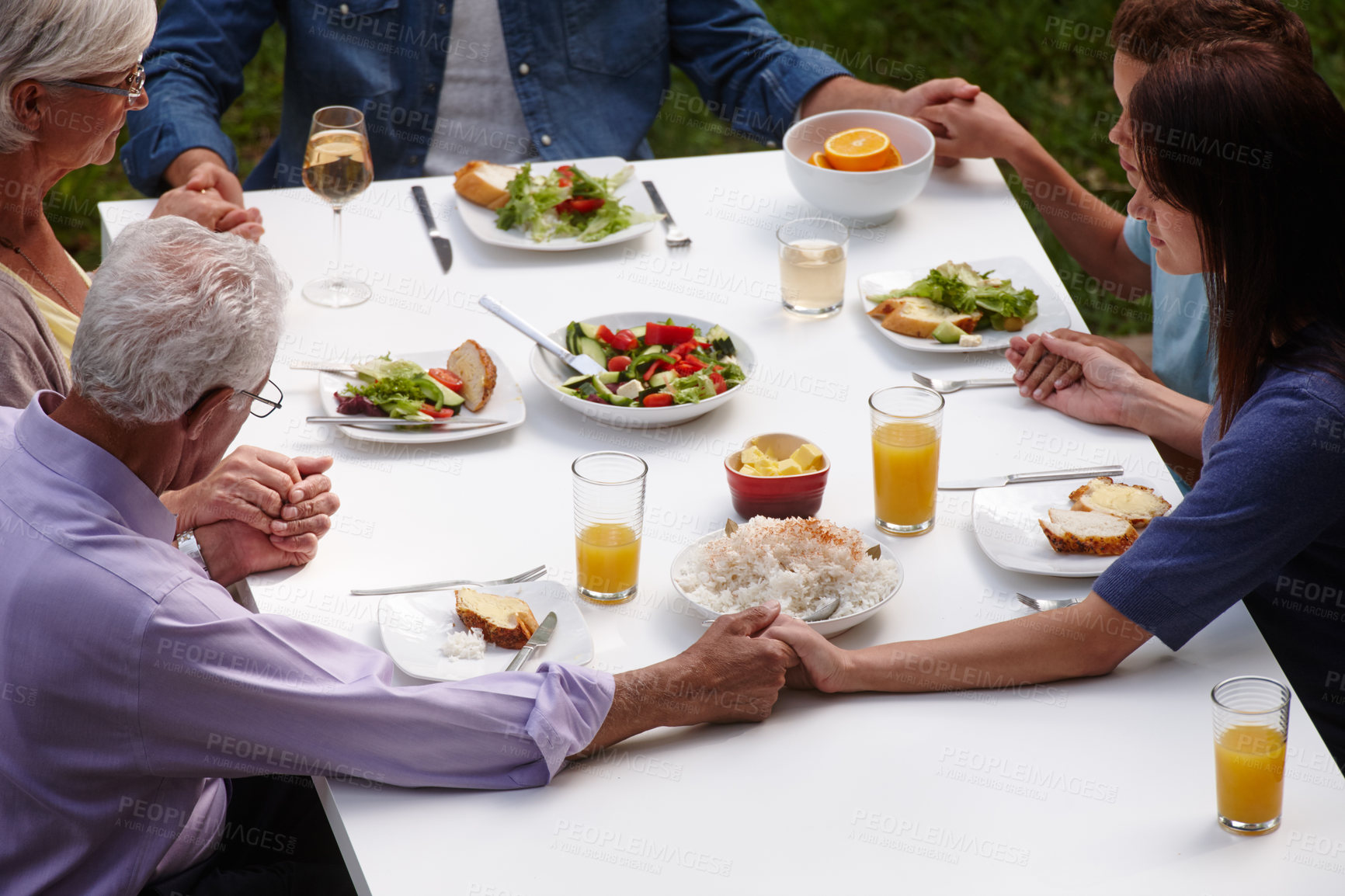 Buy stock photo Family, food and holding hands for prayer, lunch or eating together outdoor with grace, salad or faith. Grandparents, parents and children for brunch, thanksgiving or gratitude with Christmas by home