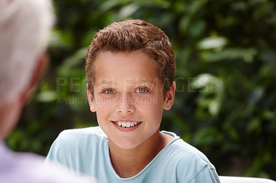 Buy stock photo Portrait of a happy little boy sitting with his family outside
