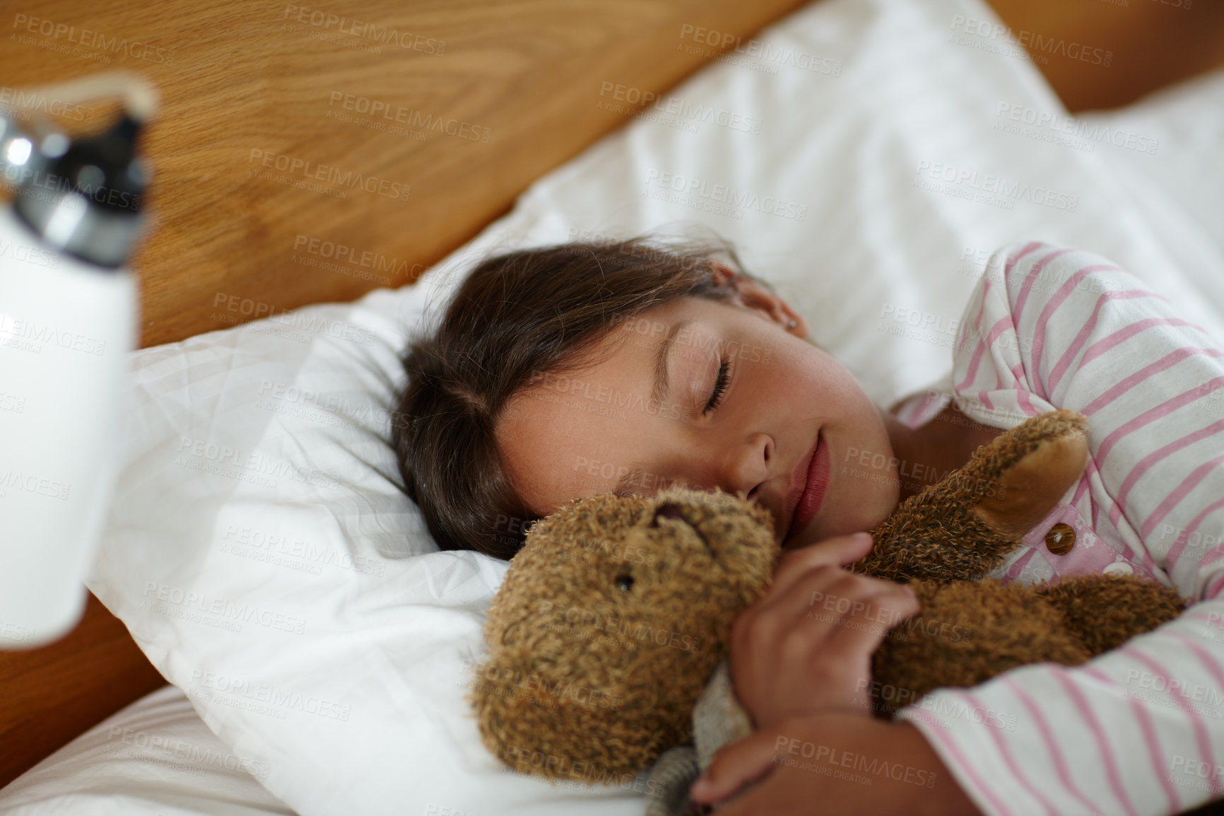 Buy stock photo Girl, child and sleeping in bed with bear, toys and tired with rest, dream and wellness in family home. Kid, teddy and plush doll in bedroom with eyes closed, exhausted and comfort with hug at house