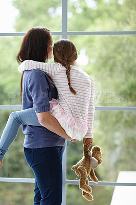 Buy stock photo Rearview shot of a loving mother and daughter looking out the window