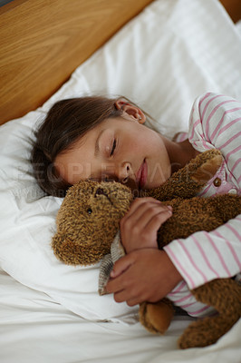 Buy stock photo Shot of a cute little girl holding her teddybear while sleeping in bed