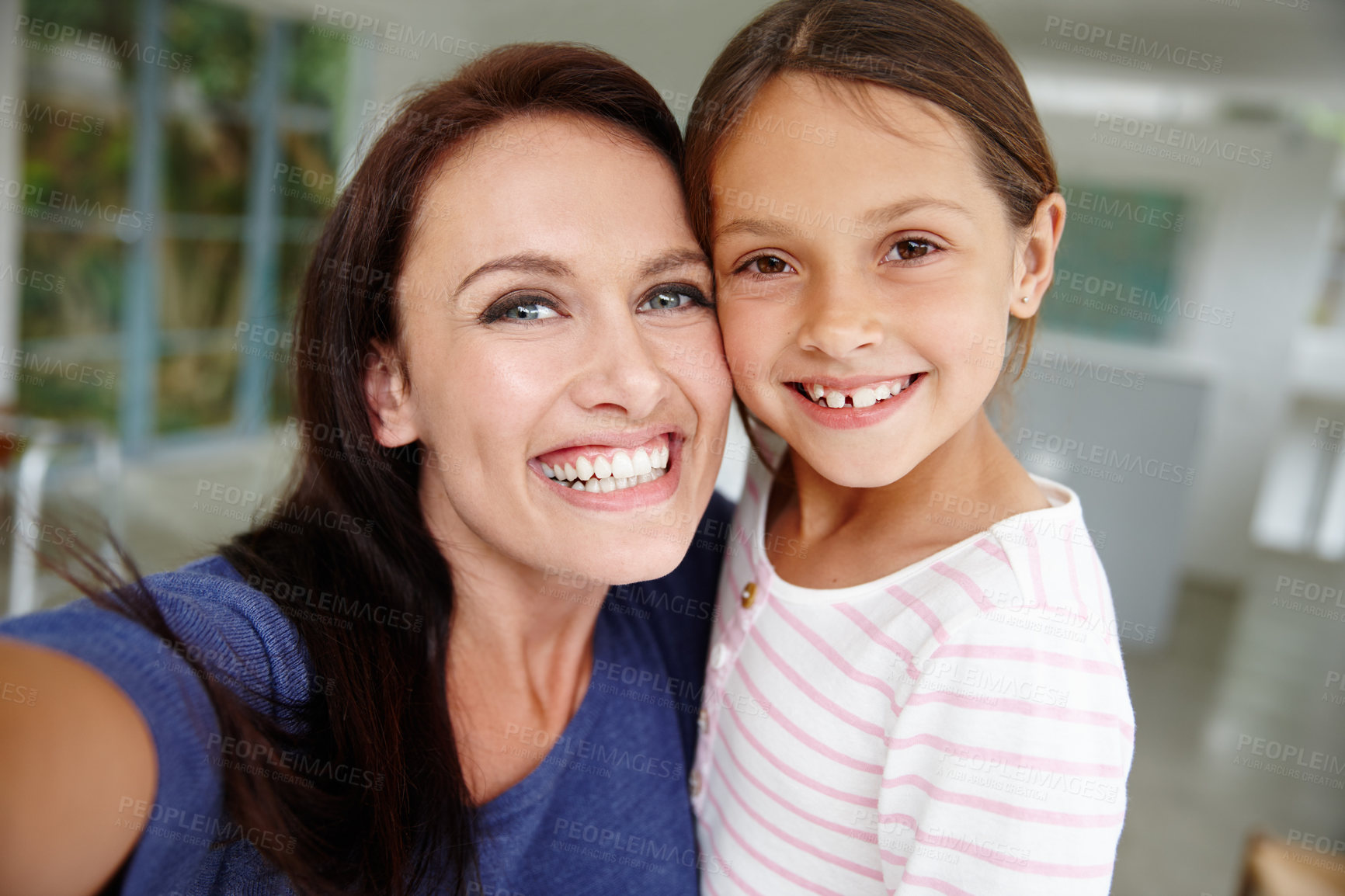 Buy stock photo Shot of a mother and daughter taking a selfie at home