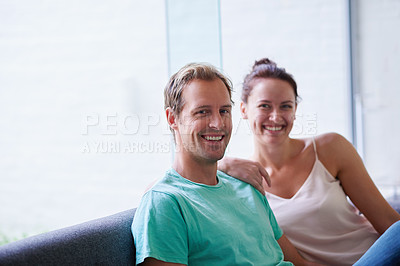Buy stock photo Portrait of an affectionate couple sitting on their sofa at home