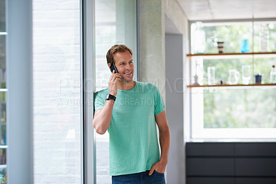 Buy stock photo A young man chatting on his cellphone at home