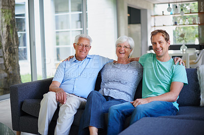 Buy stock photo Portrait of a senior couple sitting on the sofa with their son