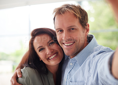 Buy stock photo Cropped portrait of an affectionate young couple taking a selfie at home