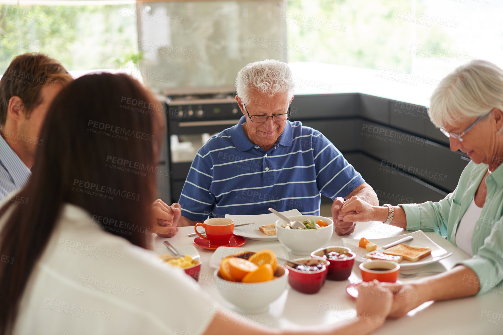 Buy stock photo Shot of a family saying a prayer before eating their food