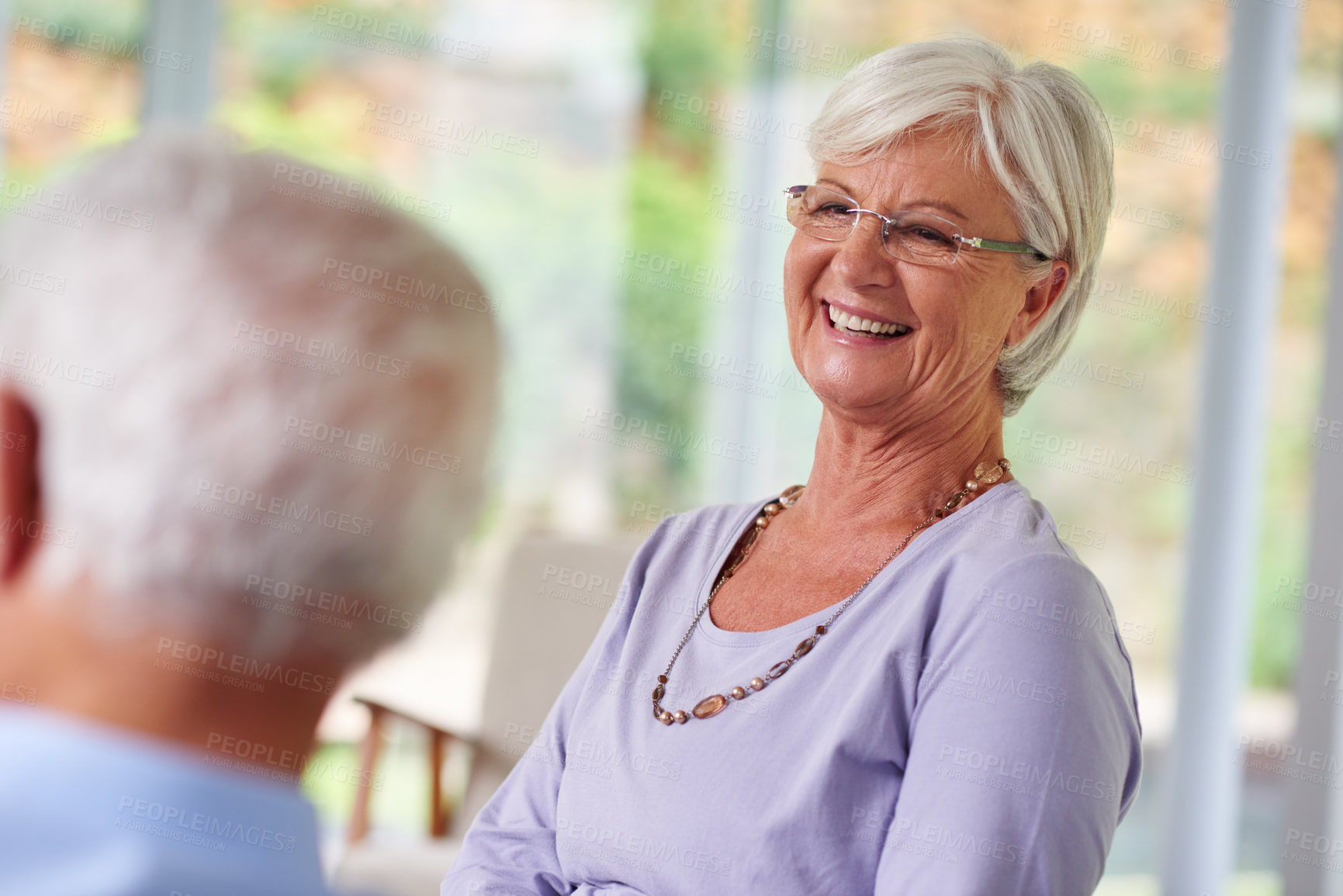 Buy stock photo Home, senior couple and smile in living room with conversation, bonding and support. People, relationship and happy or laughing as pensioners on retirement on couch on break for love, care and trust