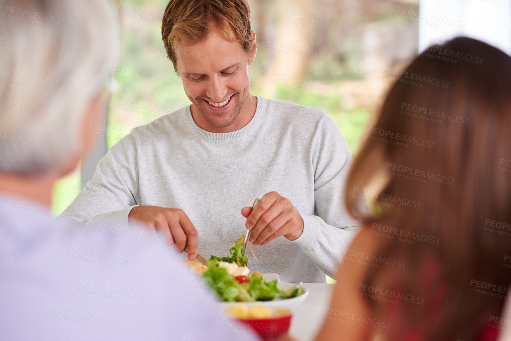 Buy stock photo Man, conversation and salad with family at lunch, celebration and event for thanksgiving in home. People, together and smile with eating, food and diet for wellness with nutrition at party in house