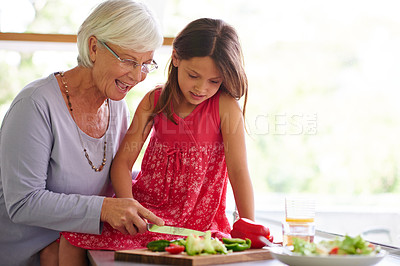 Buy stock photo Grandmother, child and cutting vegetables in home, salad ingredients and cooking together. Grandma, granddaughter and kitchen for food preparation or lunch, support and teaching kid with vegan meal