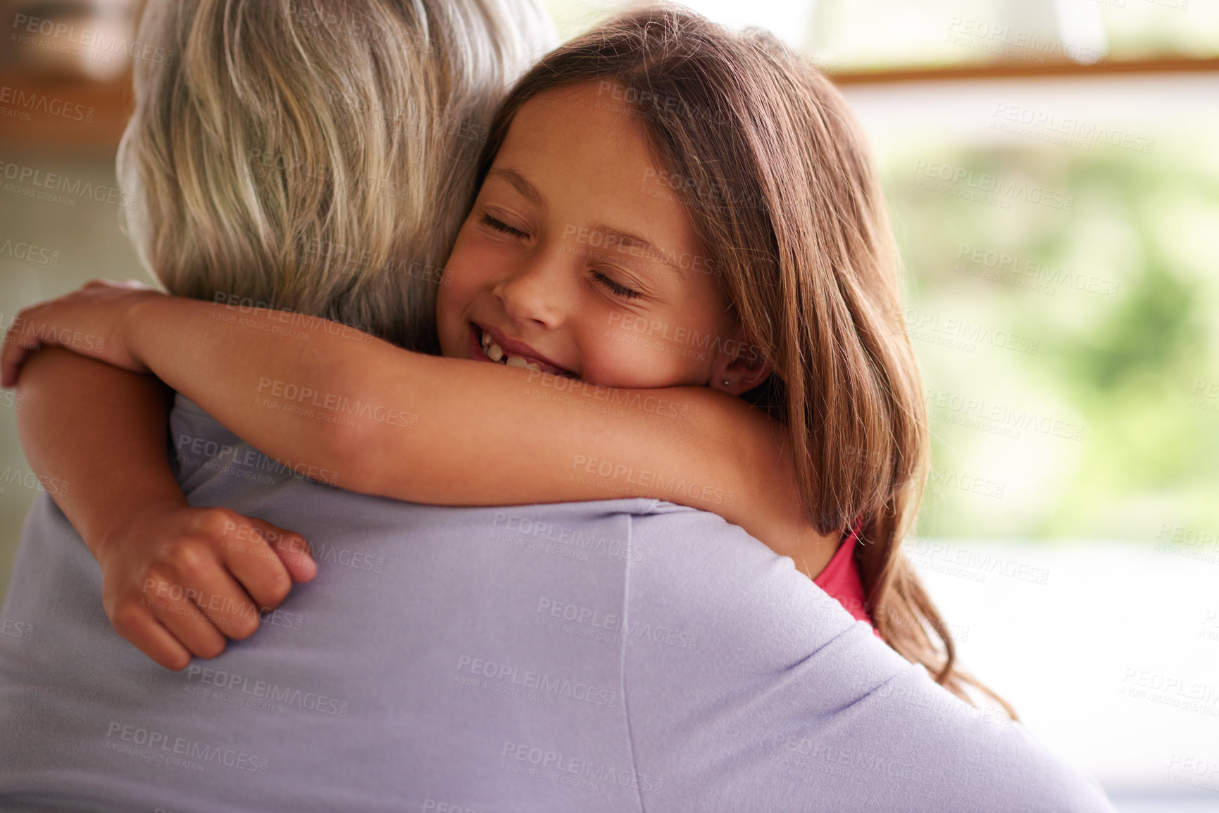 Buy stock photo Shot of a cute little girl hugging her grandmother