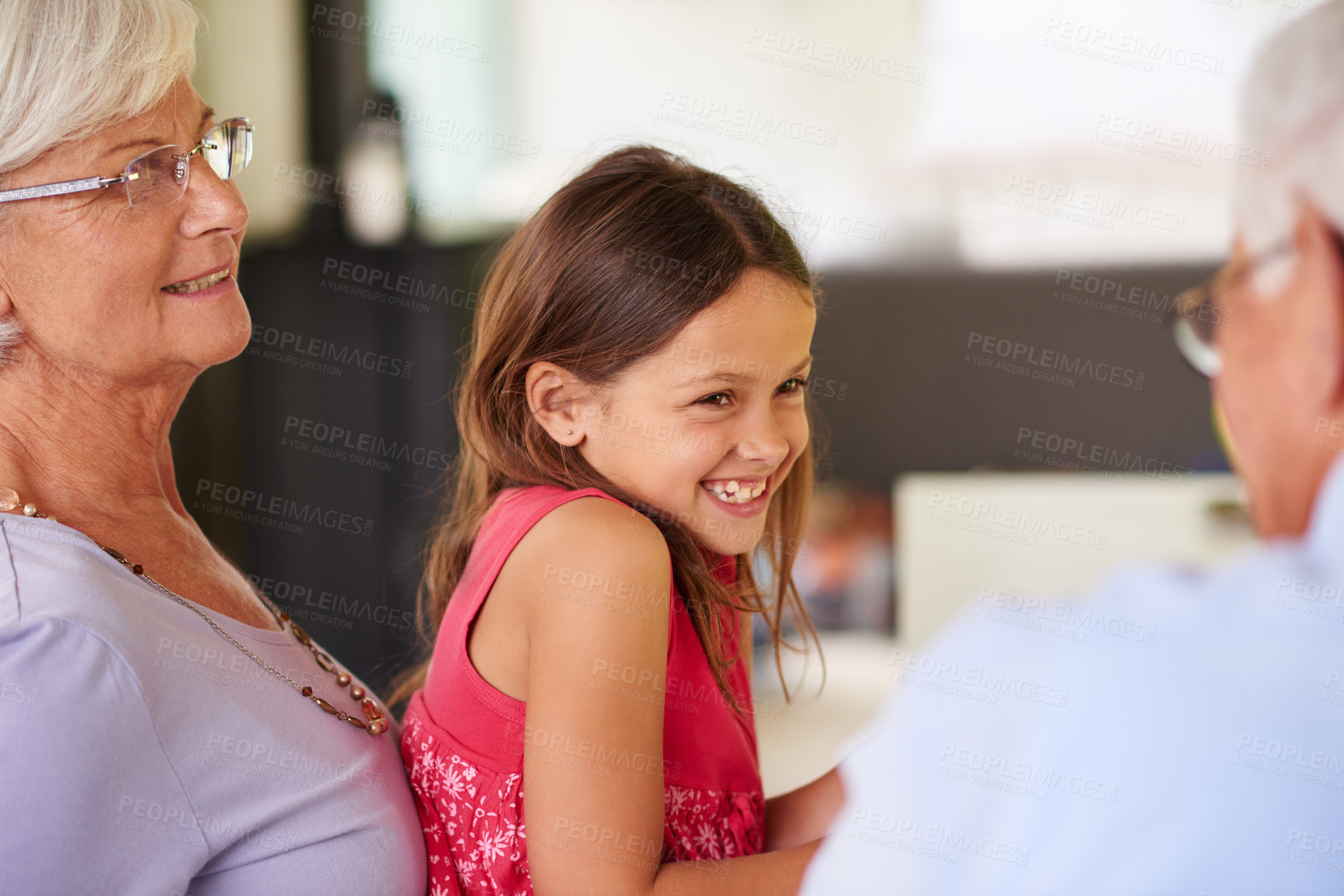 Buy stock photo Girl, child and grandparents with talking, smile and playful with funny story, bonding and love in family home. Senior man, woman and kid with comic conversation, memory and relax together on holiday