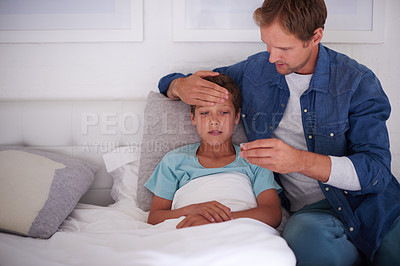 Buy stock photo Shot of a father taking care of his sick little boy at home