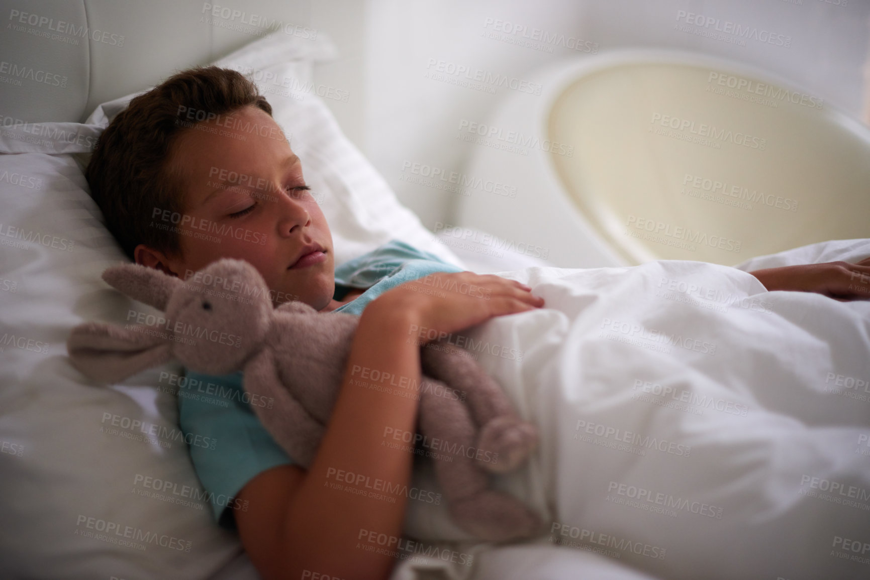 Buy stock photo Boy, child and sleeping in bed with bunny, toys and tired with rest, dream and wellness in family home. Kid, rabbit and plush doll in bedroom with eyes closed, exhausted and comfort with hug at house