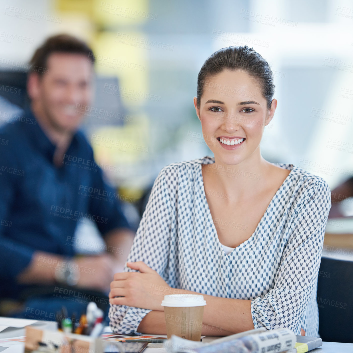 Buy stock photo Portrait of a young office worker at her desk with colleagues in the background