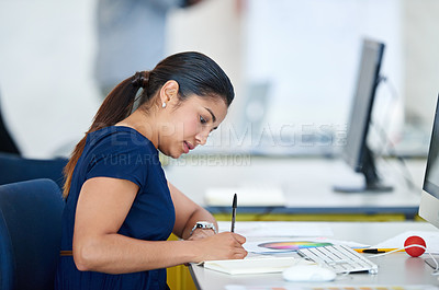 Buy stock photo Shot of an attractive young designer sitting at her desk working on a computer