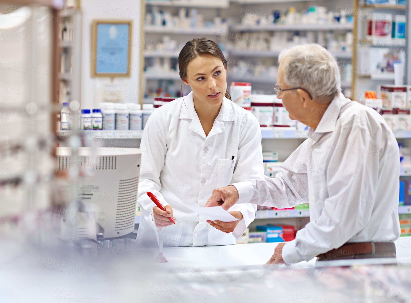 Buy stock photo Pharmacist, elderly man and document at counter for consultation, medicine prescription and healthcare advice. Woman, customer and paperwork for medical referral, script information and application