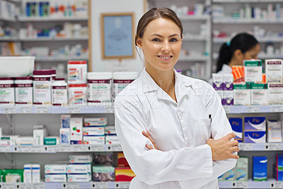 Buy stock photo Portrait of an attractive young pharmacist standing in front of shelves