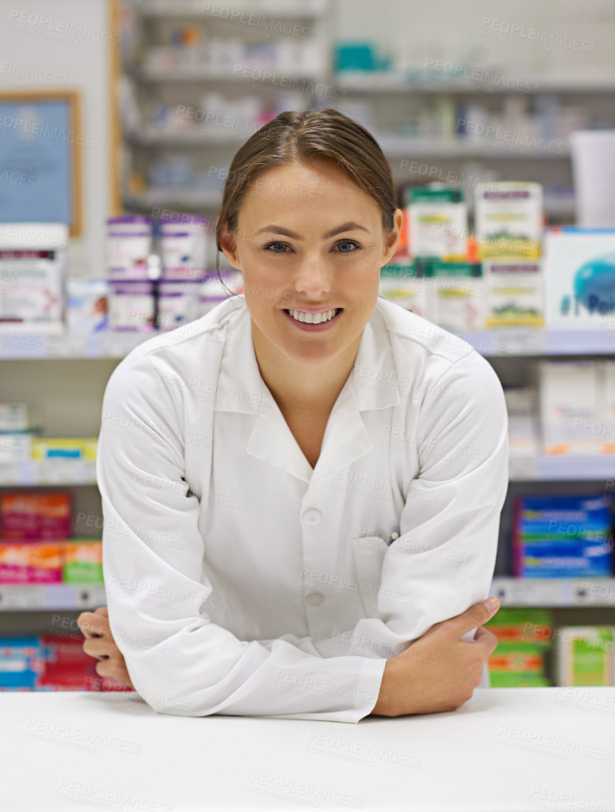 Buy stock photo Portrait of an attractive young pharmacist standing at the prescription counter