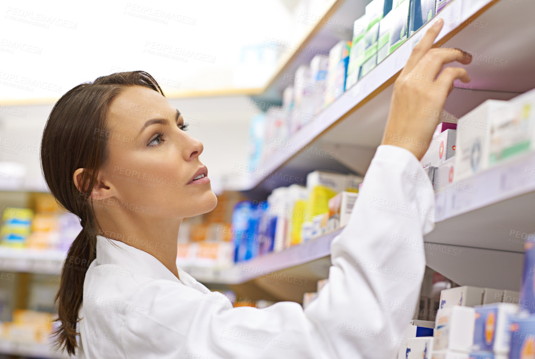 Buy stock photo Woman, serious and pharmacist on shelf at drug store for customer service and stock taking. Female person, inspection and check pills at pharmacy for packing medication and prescription at shop