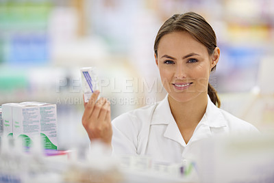 Buy stock photo Portrait of an attractive young pharmacist collecting a prescription in an aisle
