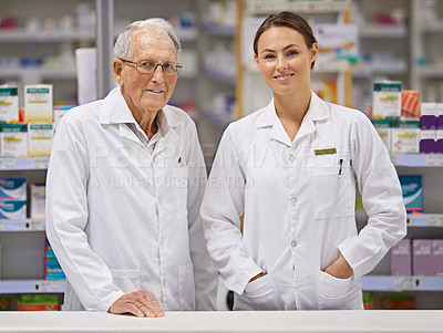 Buy stock photo Shot of an elderly pharmacist and a young pharmacist standing at counter