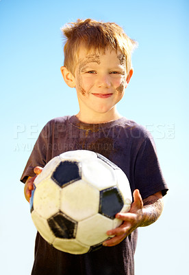 Buy stock photo Portrait, smile and child with soccer ball outdoor for sports, exercise or game in summer. Face, boy and happy kid with football with mud, messy or dirty for recreation in Switzerland on blue sky