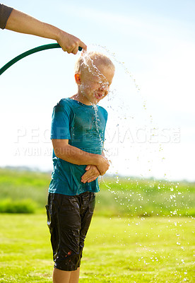 Buy stock photo Child, boy and hose pipe with water fun, splash and playing outdoor in backyard or garden for sunshine. Kid, male and person on grass or lawn with happiness, activity and enjoyment in summer weather