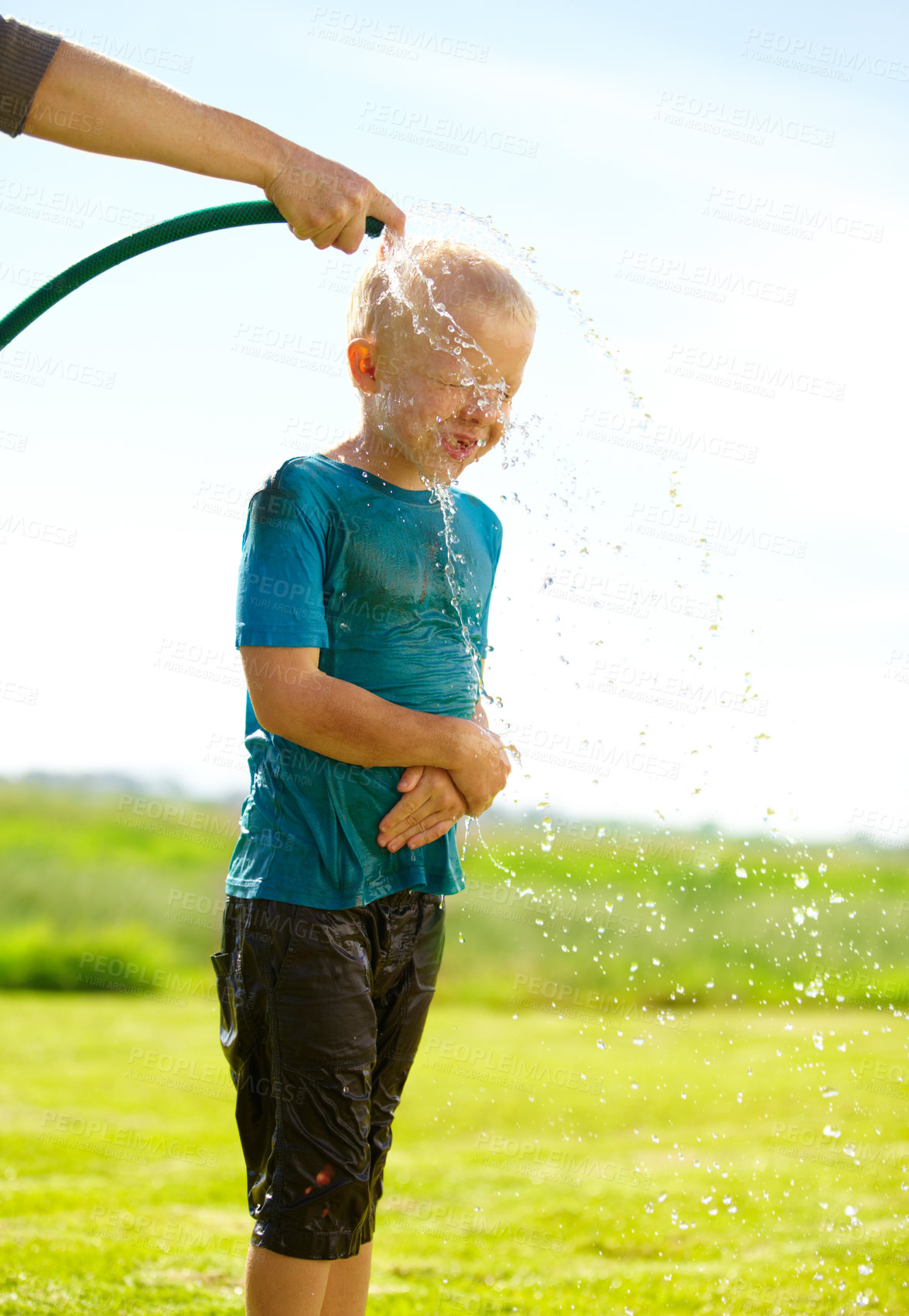 Buy stock photo Child, boy and hose pipe with water fun, splash and playing outdoor in backyard or garden for sunshine. Kid, male and person on grass or lawn with happiness, activity and enjoyment in summer weather