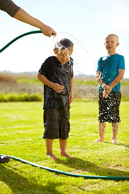 Buy stock photo Children, boys and hose pipe with splash, water fun and playing outdoor in backyard or garden for sunshine. Kids, brother and people on grass or lawn with happiness, activity and enjoyment in summer
