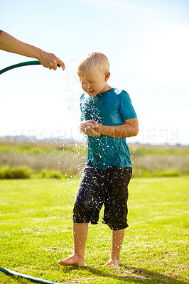 Buy stock photo Kid, boy and hose pipe with splash, water fun and playing outdoor in backyard or garden for sunshine. Child, male and person on grass or lawn with happiness, activity and enjoyment in summer weather