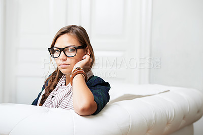 Buy stock photo Portrait, home and woman in glasses on sofa for fashion in living room of house or apartment. Face, eyewear and serious girl in lounge relax on couch in style, cool clothes or trendy in Switzerland