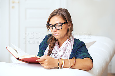 Buy stock photo Thinking, reading and woman on sofa with book, knowledge and learning with literature in home. Relax, paperback and studying in apartment, girl in glasses on couch with story journal in living room.