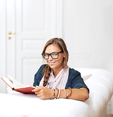 Buy stock photo Smile, portrait and woman on sofa reading, knowledge and learning with literature in home. Relax, book and studying in apartment, happy girl in glasses on couch with story journal in living room.