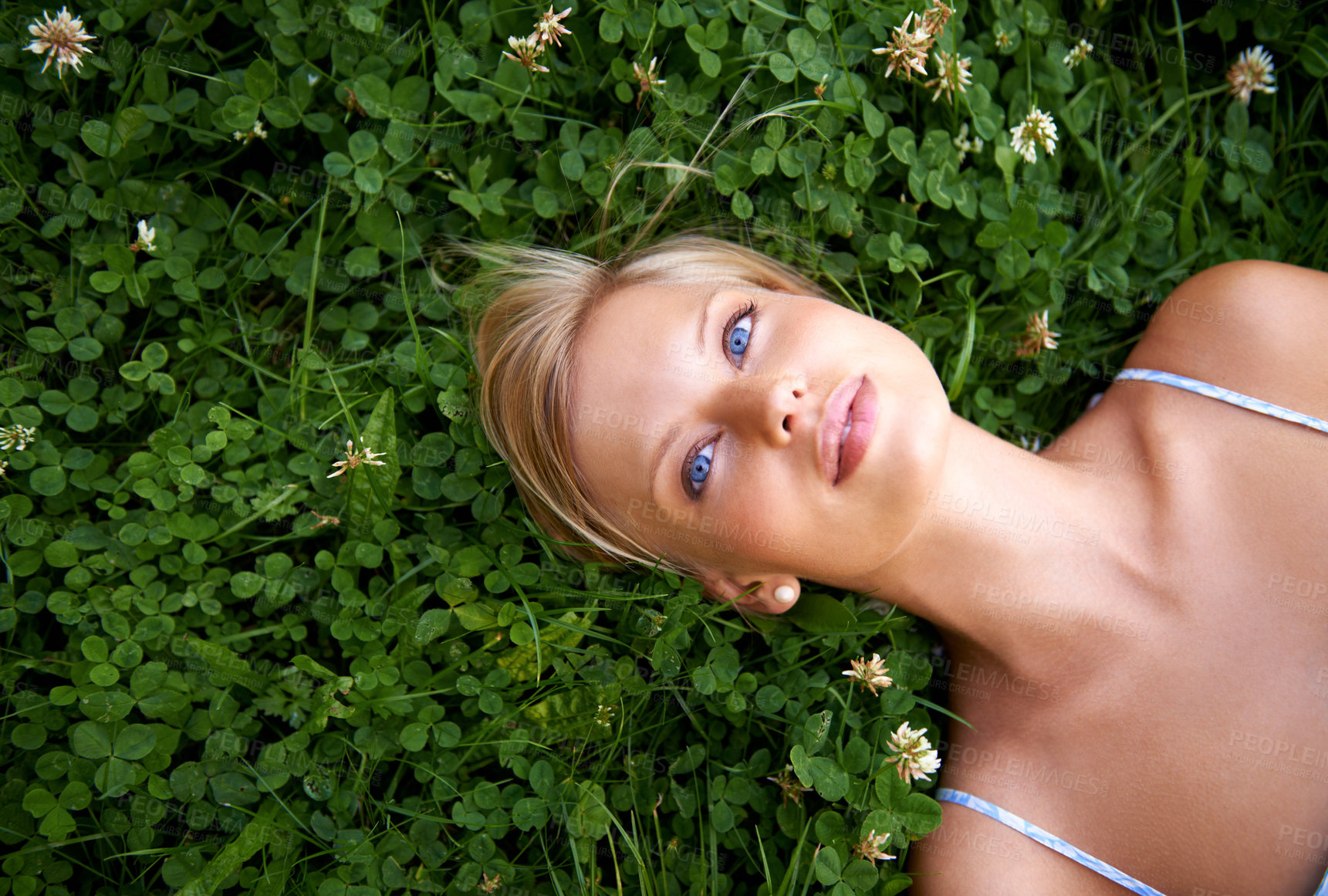 Buy stock photo Spring, thinking and relax with woman on grass in nature for calm, environment and peace. Park, flowers and field with face of female person lying in countryside for summer, vacation and wellness