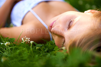 Buy stock photo Spring, sleeping and relax with woman on grass in nature for calm, park and peace. Holiday, flowers and field with face of female person lying in countryside meadow for summer, vacation and wellness